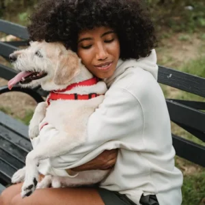 Person hugging emotional support dog for mental health comfort and anxiety relief